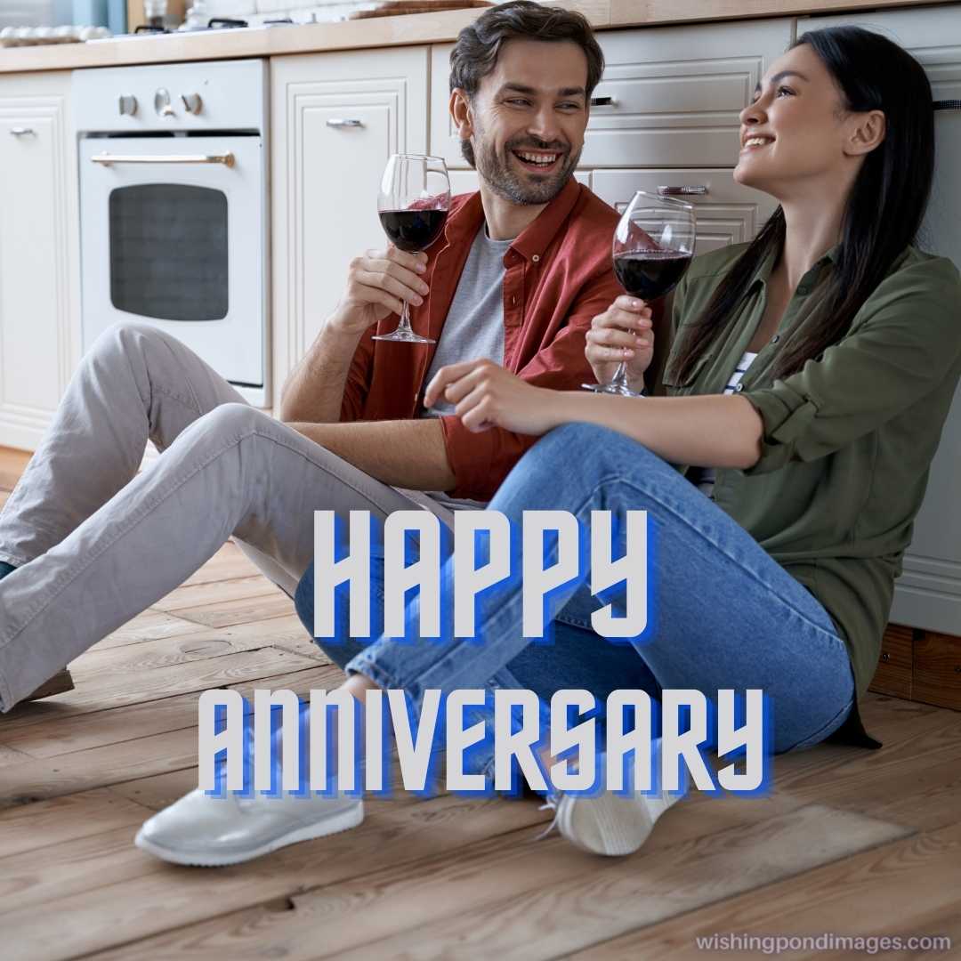 Celebrating the anniversary, the full length of a young beautiful couple sitting on the floor in the