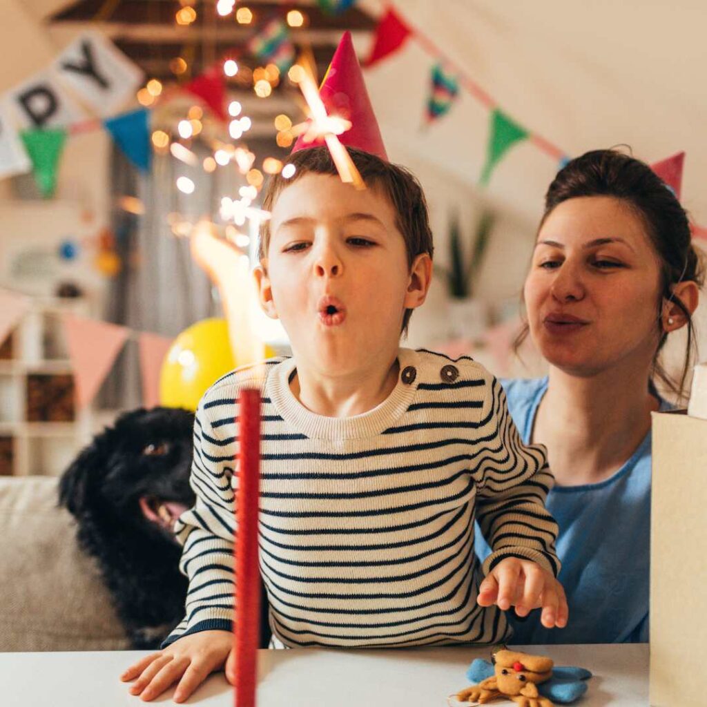 Preschooler child at home with his mother, blowing out birthday candles - Happy Birthday Images