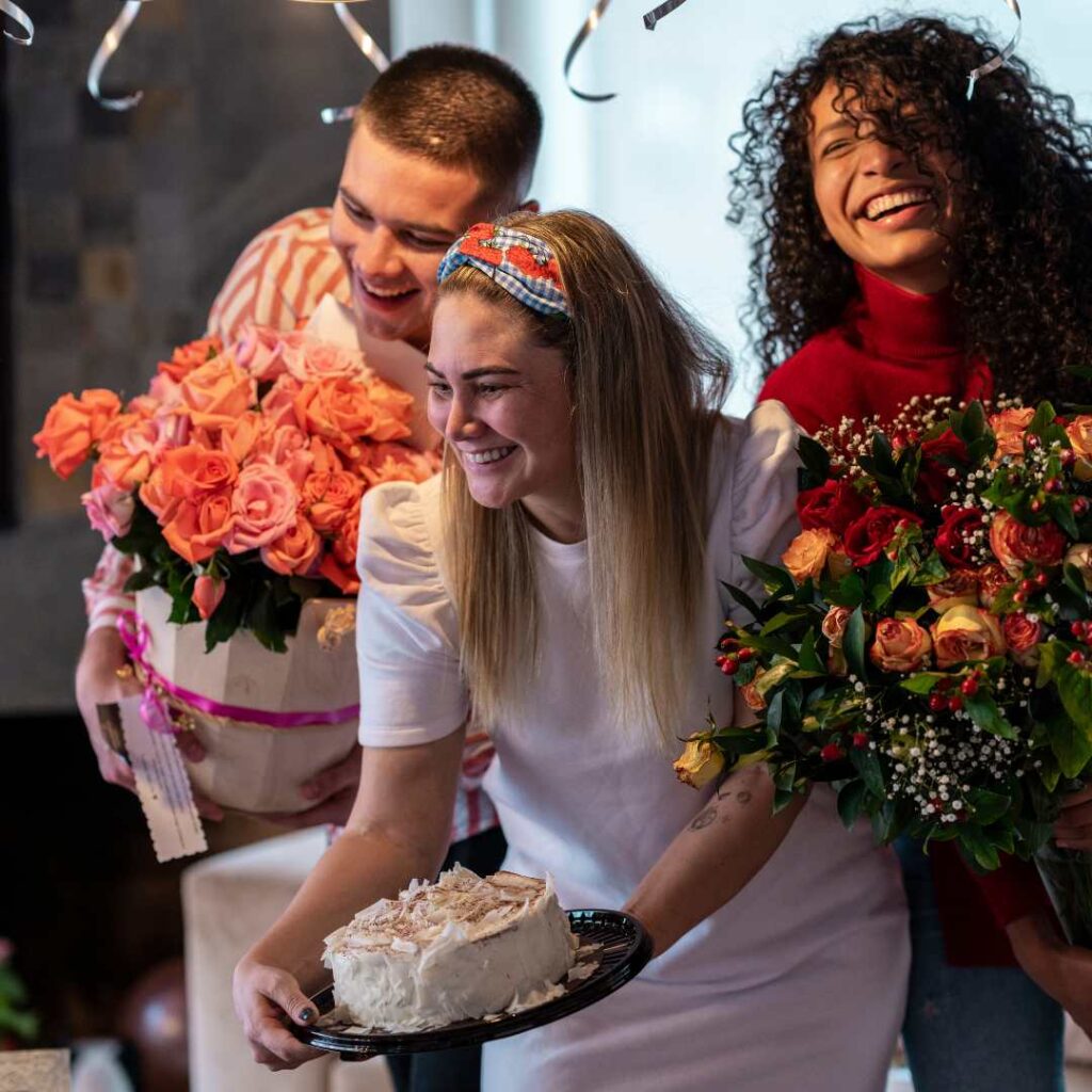 A young beautiful girl holding a birthday cake and smiling with her friends - Happy Birthday Images